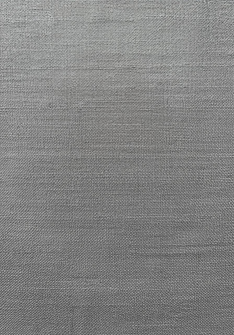 Gros plan sur la texture d'un tissu en lin lavé de qualité, montrant la richesse du tissage et les irrégularités naturelles des fibres.