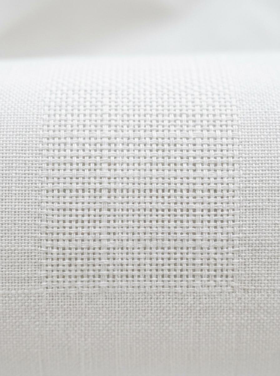 Gros plan sur le tissage serré et uniforme d'un tissu en percale de coton, montrant la densité des fils comme gage de qualité.