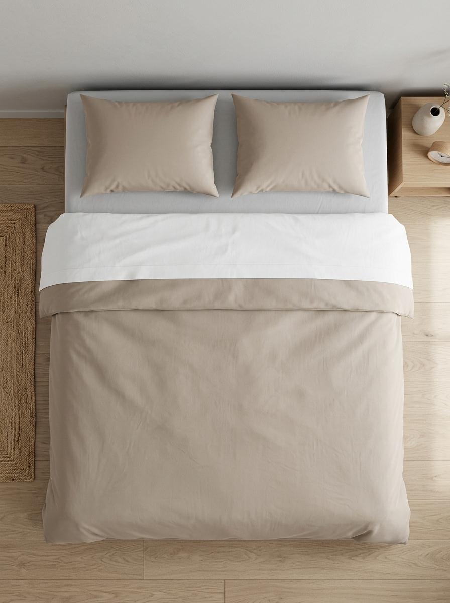 Vue de dessus d'un lit parfaitement fait, montrant les couches superposées : drap-housse gris, drap plat blanc, et couette beige.