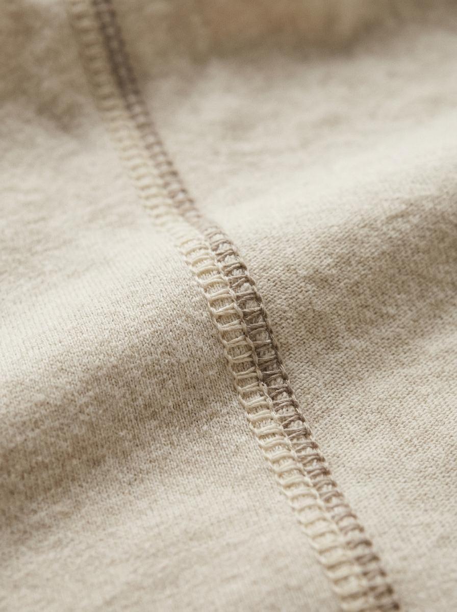 Gros plan sur une couture plate et lisse à l'intérieur d'un vêtement en coton bio, un détail conçu pour ne pas irriter la peau.