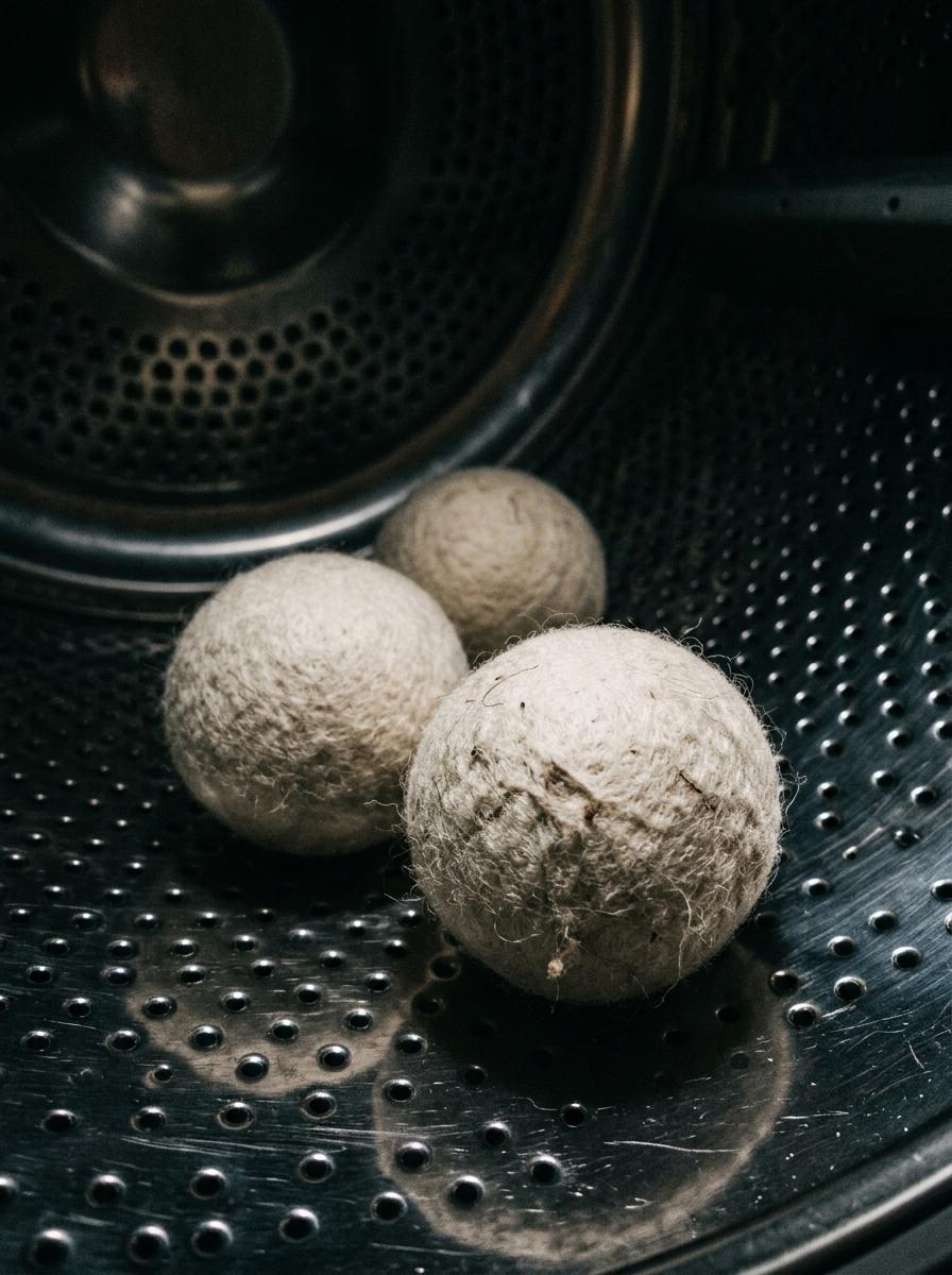Gros plan sur trois balles de séchage en laine à l'intérieur d'un tambour de sèche-linge, une alternative écologique.