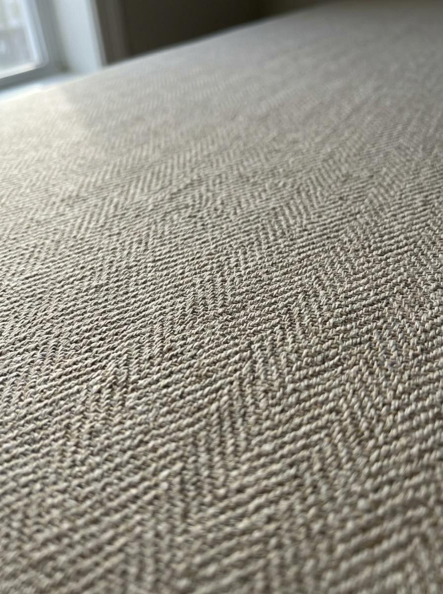 Macro-photographie du tissu respirant d'un sommier tapissier, montrant la qualité et la texture du tissage.